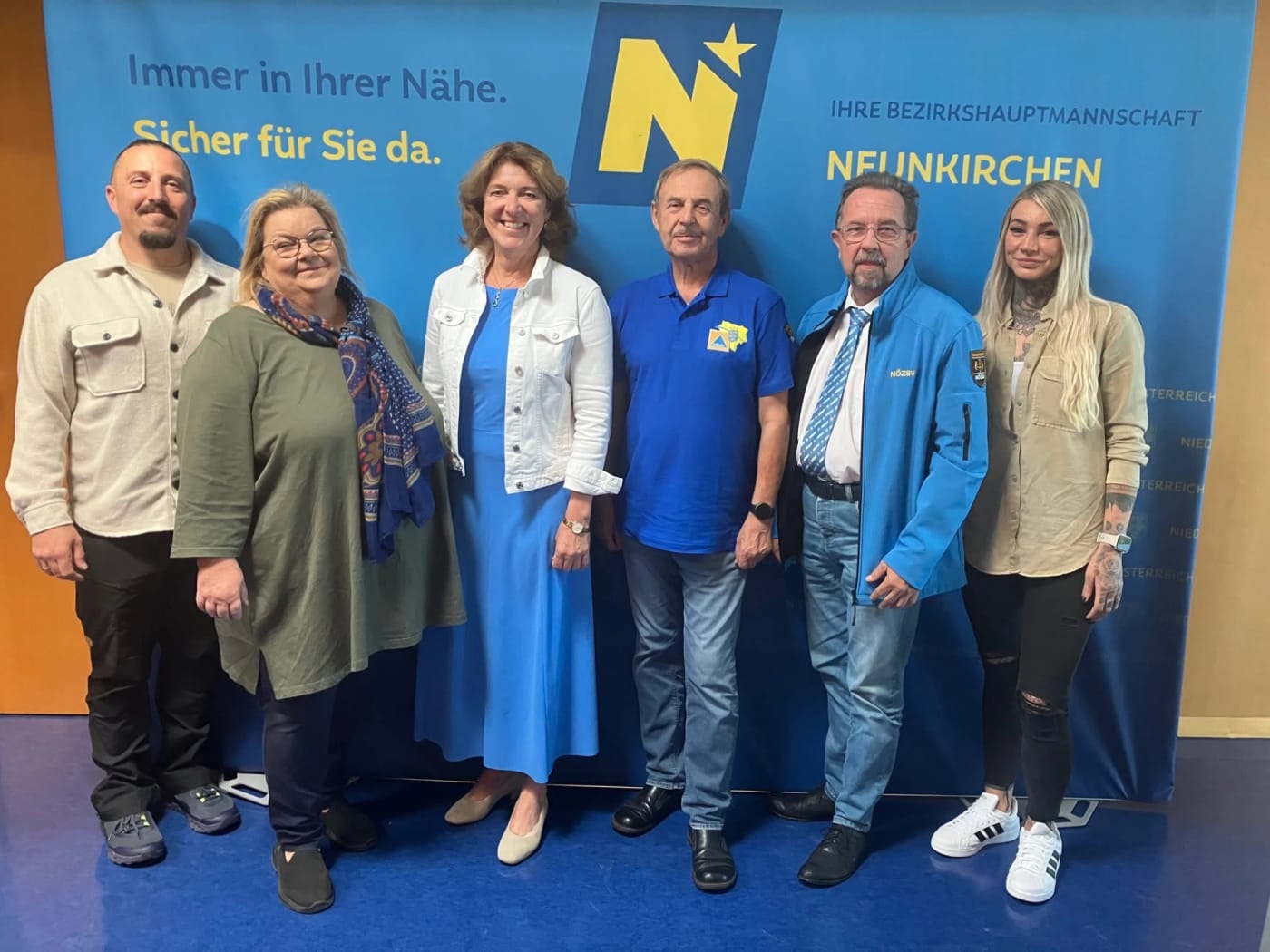 Gruppenfoto mit sechs Personen vor der Pressewand der Bezirkshauptmannschaft Neunkirchen